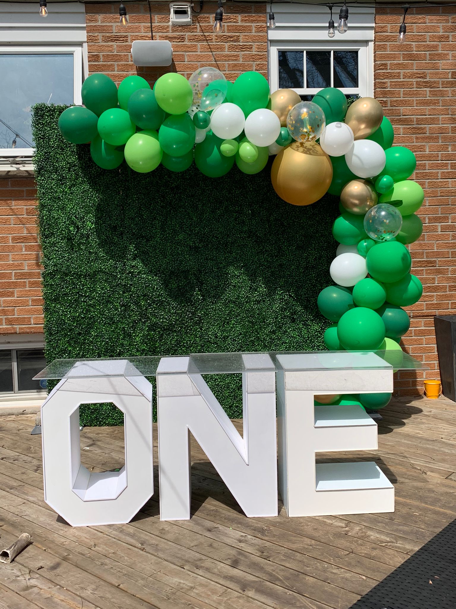 Green boxwood wall with balloon decor in Niagara Falls and marquee letters