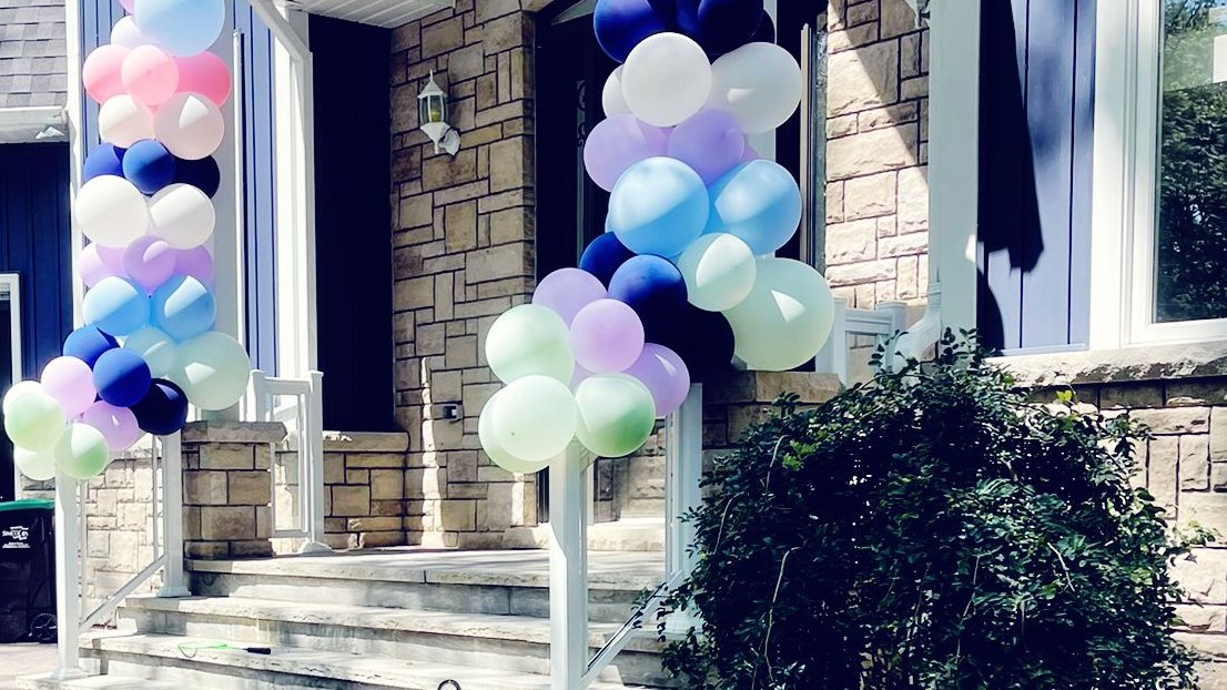 Two balloon columns standing either side of a front entrance