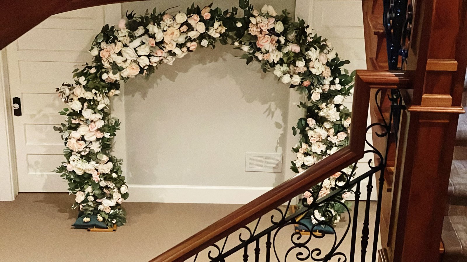 A floral moon gate arch standing on wooden bases in a house entrance hall