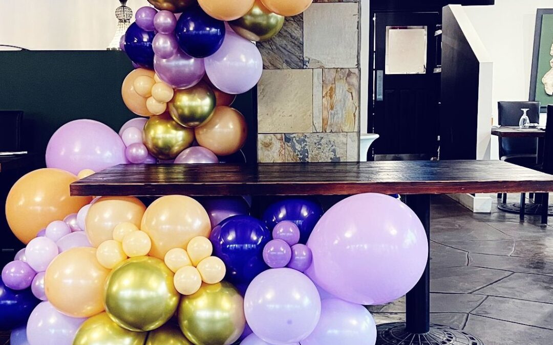 A balloon garland running along the front of a table at a party